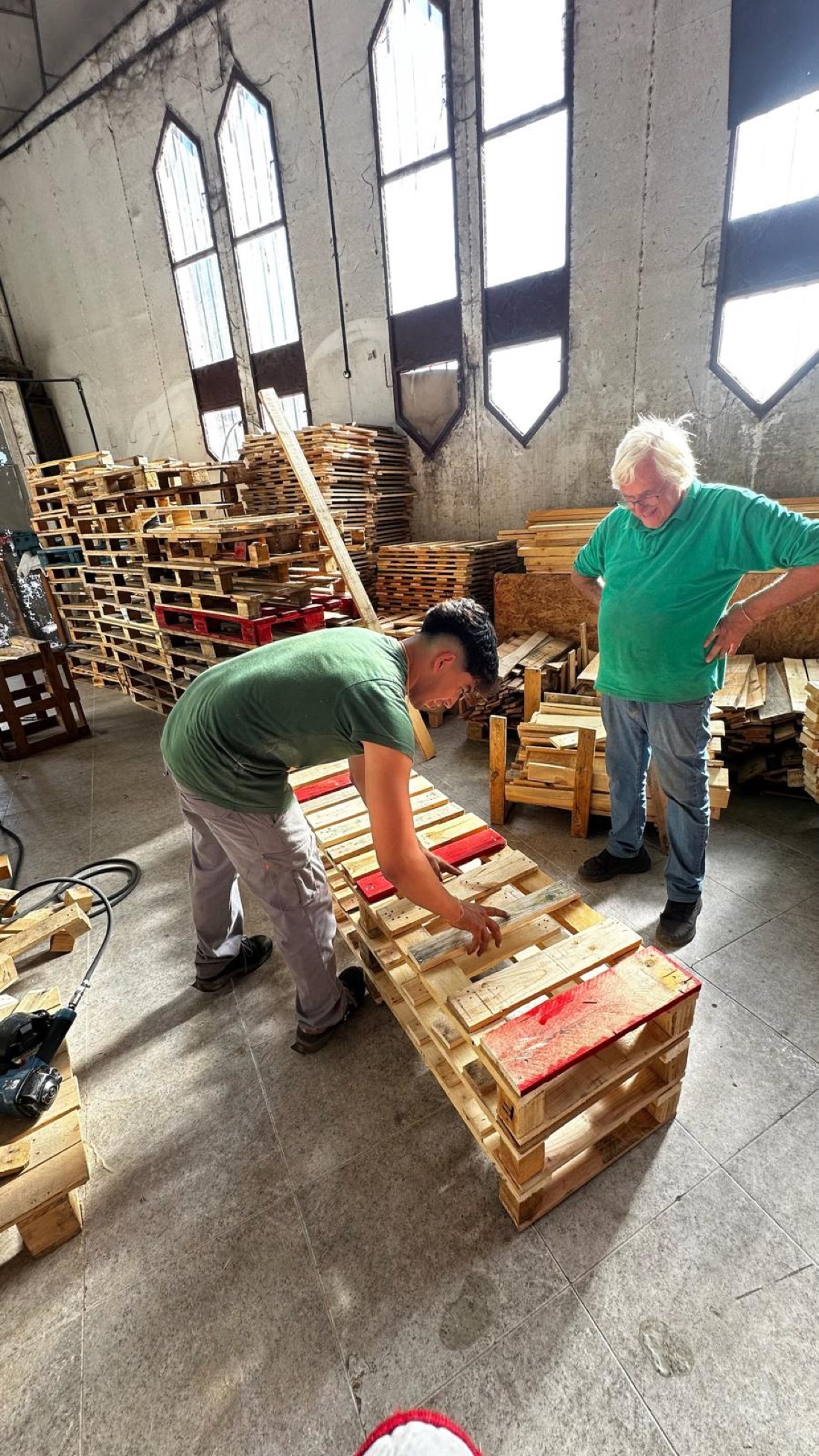 Manuel y Santiago Jiménez montando un banco con palets reciclados en la nave de Terrassa